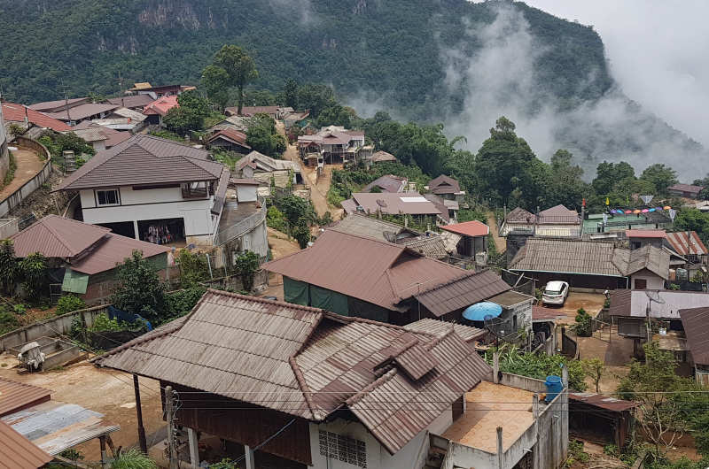 Poblado rural en el norte de Tailandia con viviendas humildes y coches