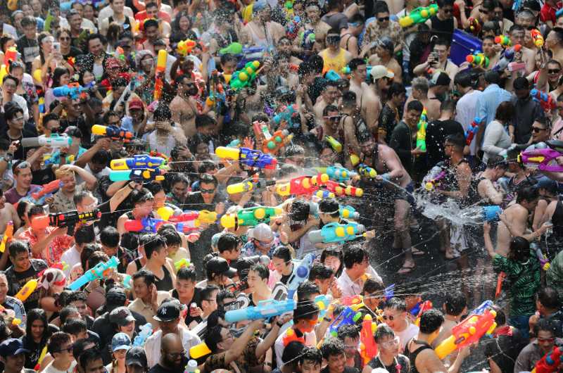 Multitud celebrando Songkran en Bangkok con pistolas de agua