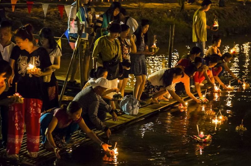 Personas depositando krathongs en el río en Tailandia