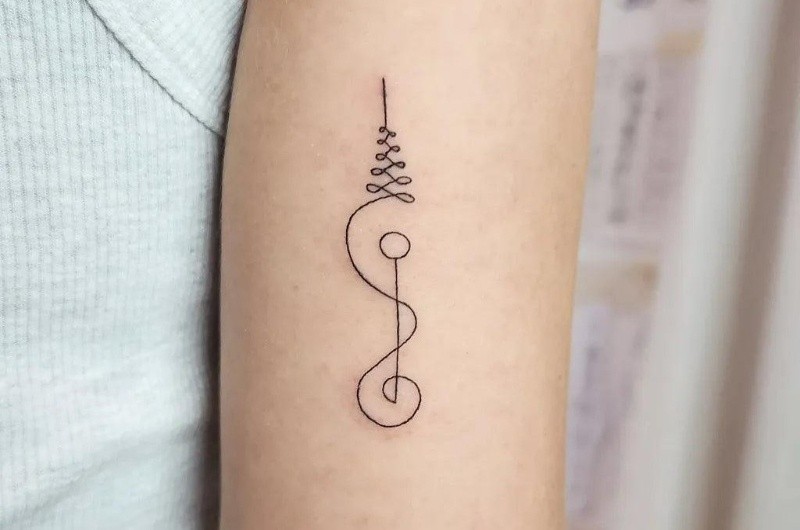 Pequeño tatuaje Sak Yant en lel brazo