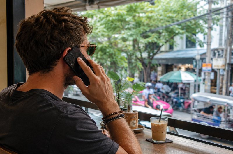 Turista llamando por teléfono móvil durante un viaje por Tailandia