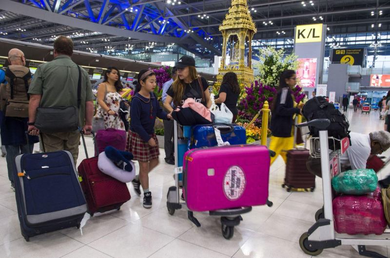 Viajeros con maletas en el aeropuerto de Bangkok