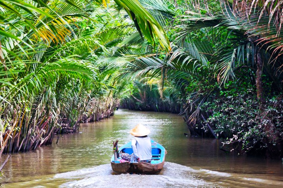 Barca navegando por los canales del Delta del Mekong durante la temporada de lluvias