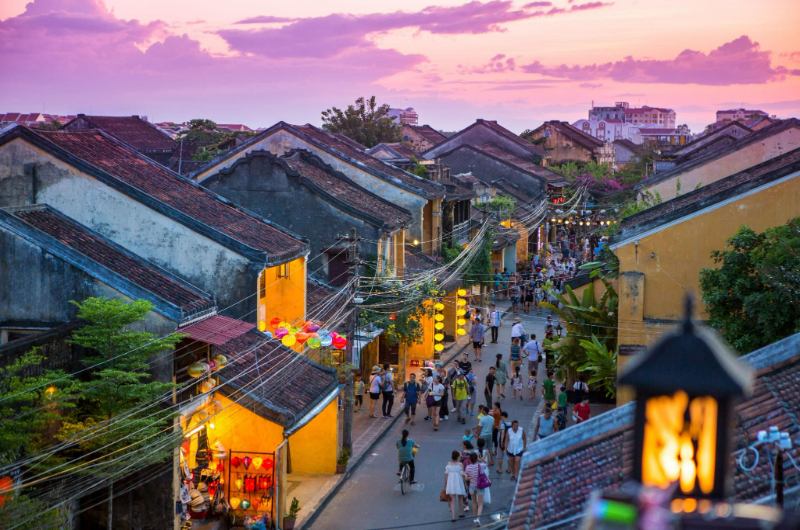 Turistas caminando por el centro de Hoi An al atardecer