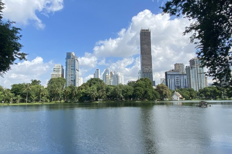 Lago de Lumpini Park con los rascacielos de Bangkok al fondo en un día soleado