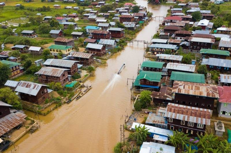 Barca navegando por un canal del Delta del Mekong junto a viviendas ribereñas