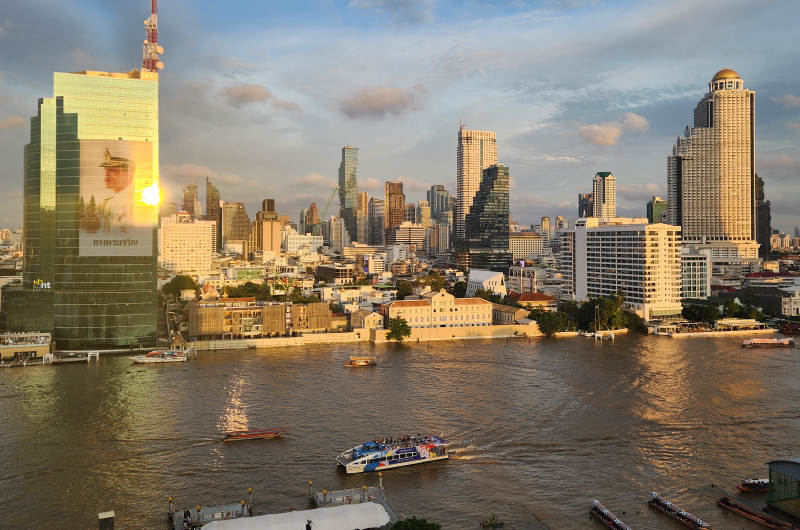 Barco turístico navegando por el río Chao Phraya con el skyline de Bangkok al fondo