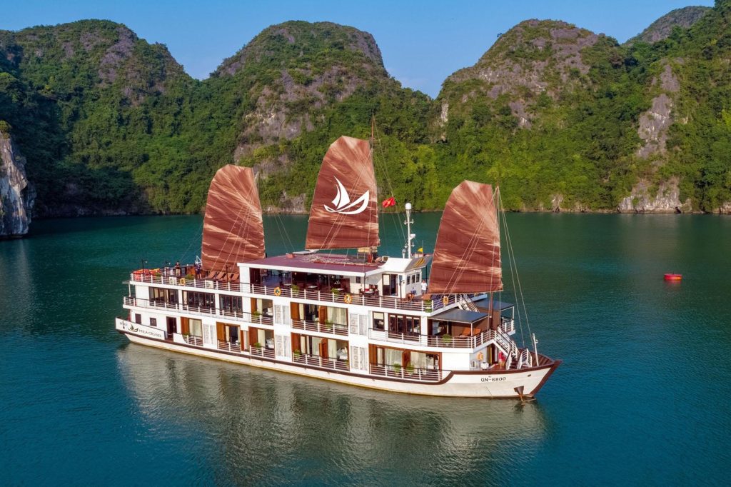 Crucero navegando por la bahía de Halong en un día despejado durante el mes de mayo.