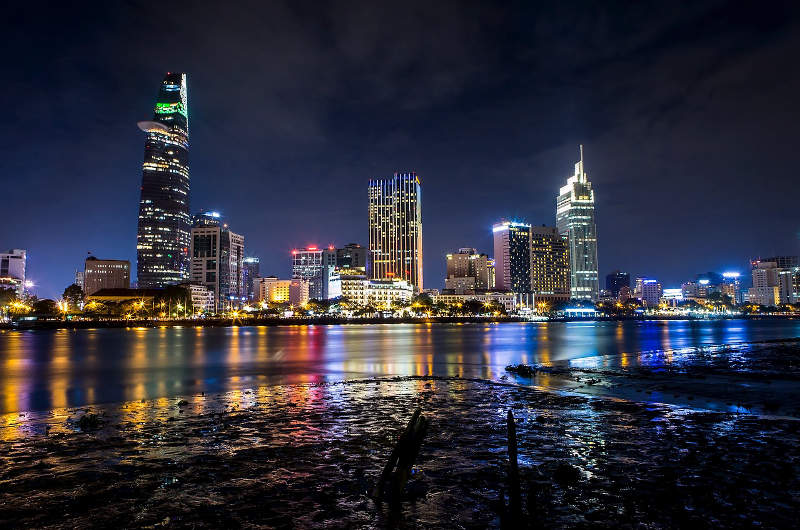 Vista nocturna del río Saigón con los edificios iluminados de Ho Chi Minh