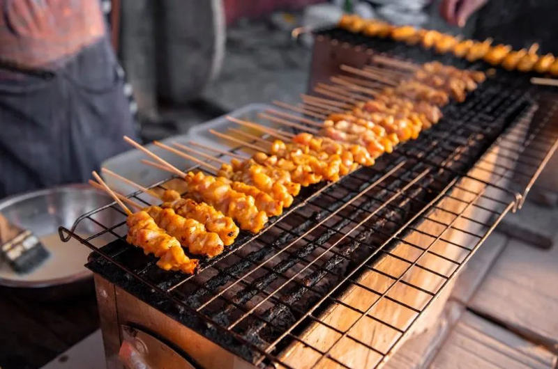 Moo Satay, pinchos con salsa de cacahuete en un puesto de street food en Tailandia