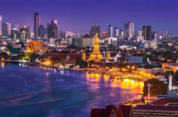 vista nocturna de los barrios de Bangkok junto al río Chao Phraya con Wat Arun iluminado