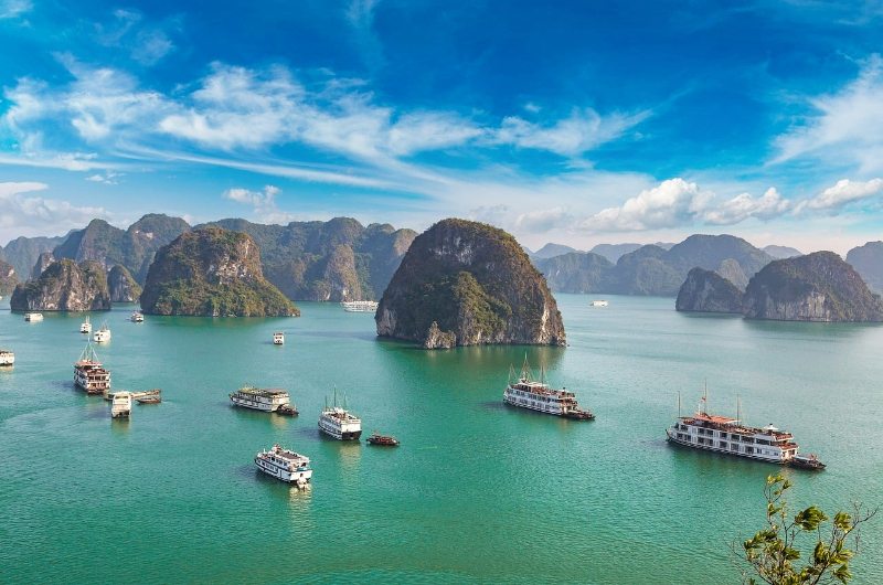 Vista de la Bahía de Halong en octubre con cielo despejado, algunas nubes y aguas tranquilas