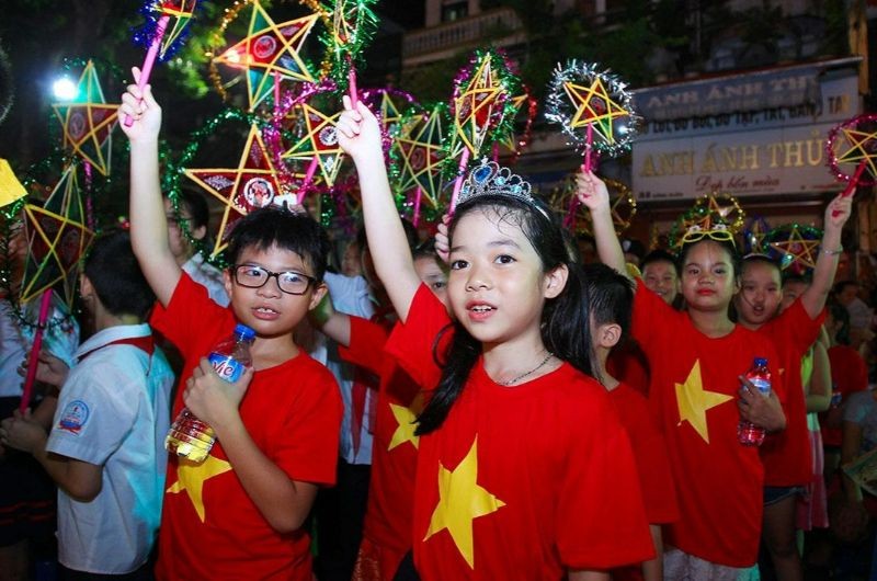 Niños sosteniendo estrellas iluminadas durante el Festival del Medio Otoño en Vietnam