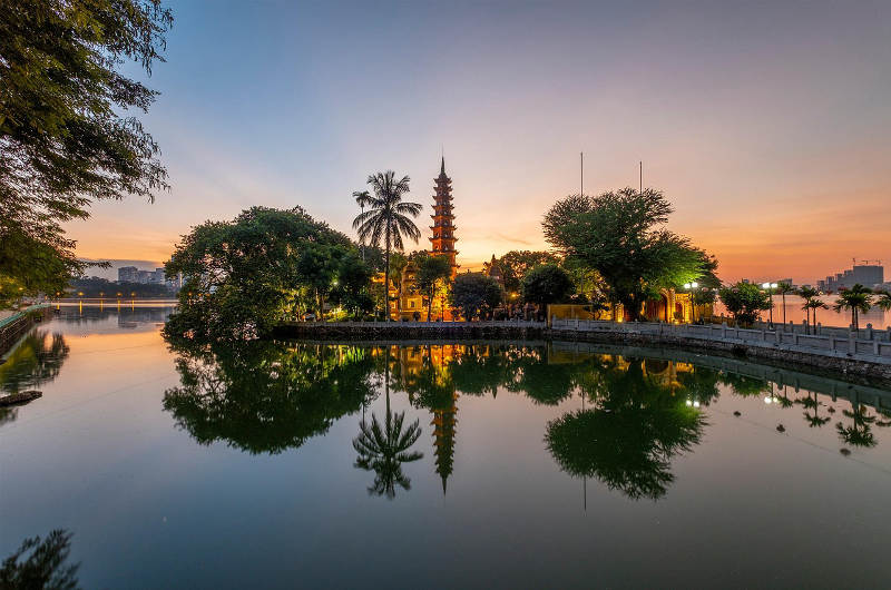 Pagoda Tran Quoc iluminada al atardecer junto al lago Oeste en Hanói