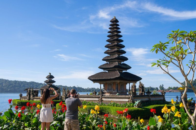 Pareja de turistas en el templo Ulun Danu en Bali