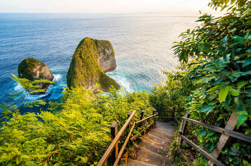 Escaleras de bajada a Kelingking Beach con vista de las rocas y el mar desde el acantilado