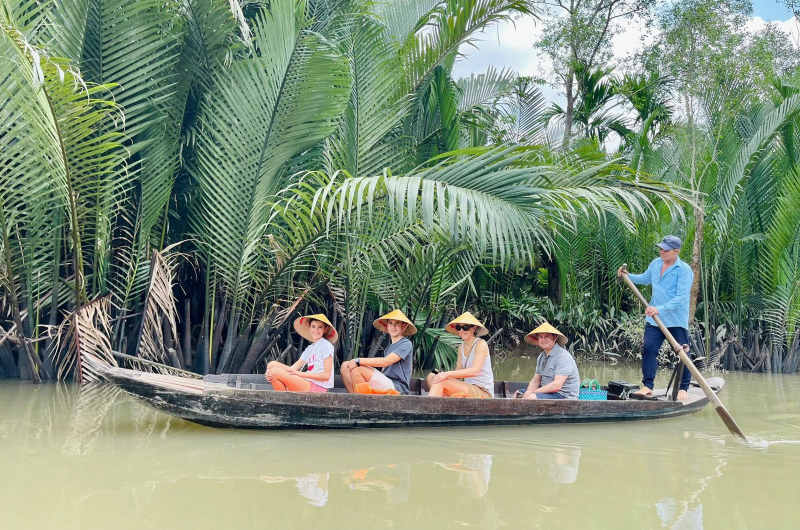 Turistas navegando en barca por un canal del delta del Mekong
