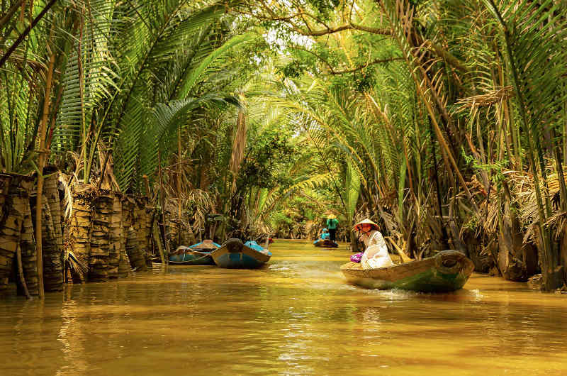 Barca tradicional navegando por los canales de Ben Tre en el delta del Mekong en el sur de Vietnam