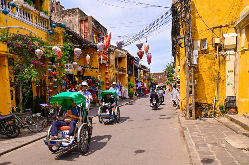 Calle del centro histórico de Hoi An con cyclo tradicionales en Vietnam