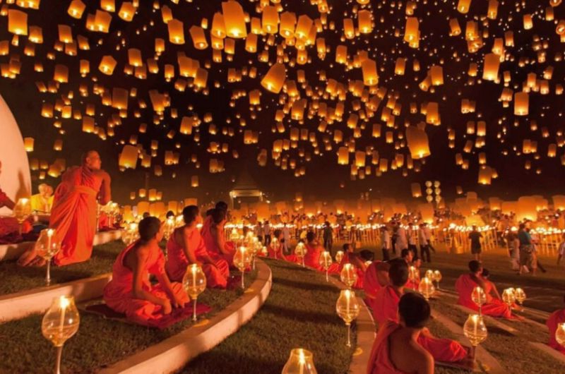 Monjes contemplando linternas subiendo al cielo durante Yi Peng en Chiang Mai