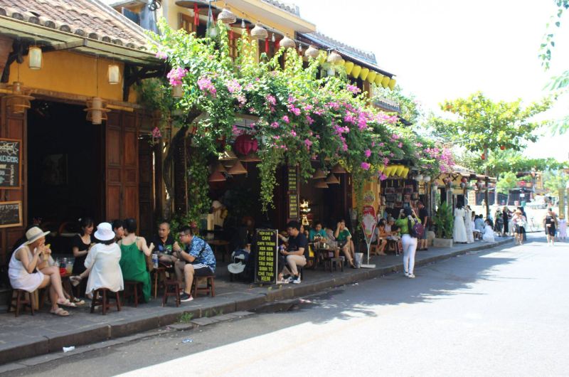 Turistas sentados en las terrazas de las cafeterías del casco antiguo de Hoi An durante enero