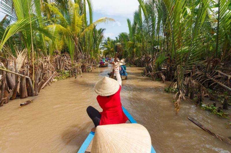 Turistas recorriendo en barca un canal del Delta del Mekong durante enero