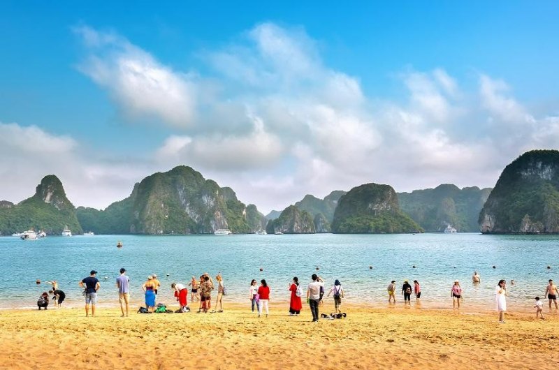 Turistas bañándose en la playa de Ti Top durante un crucero por la bahía de Halong
