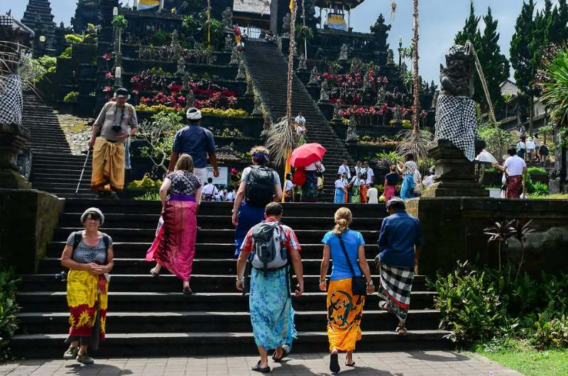 Turistas con sarong visitando el templo Besakih en Bali