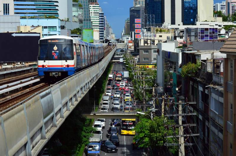 BTS circulando sobre una calle con tráfico en Bangkok